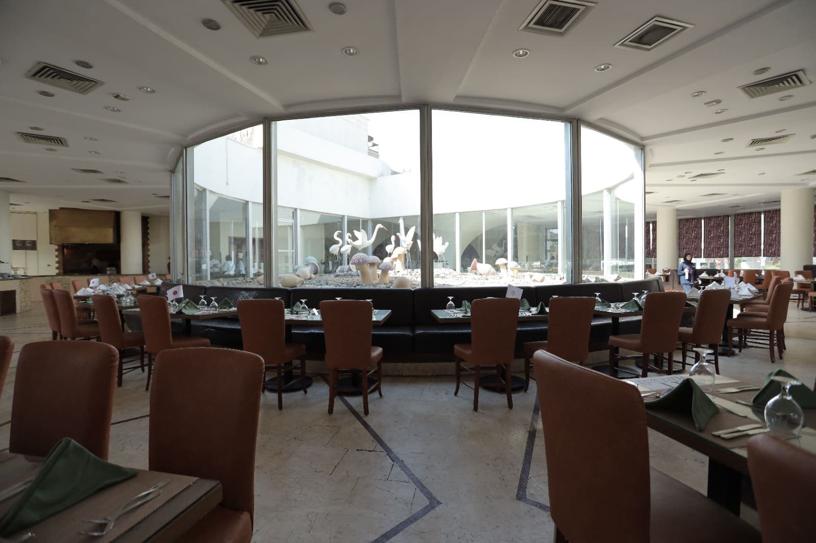 The hotel restaurant, tables set around a glass-walled central court
